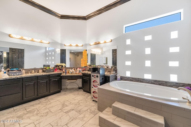 bathroom with tiled tub, vanity, a high ceiling, tile patterned flooring, and crown molding