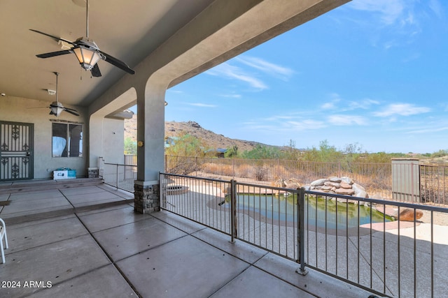 view of patio with ceiling fan and a mountain view