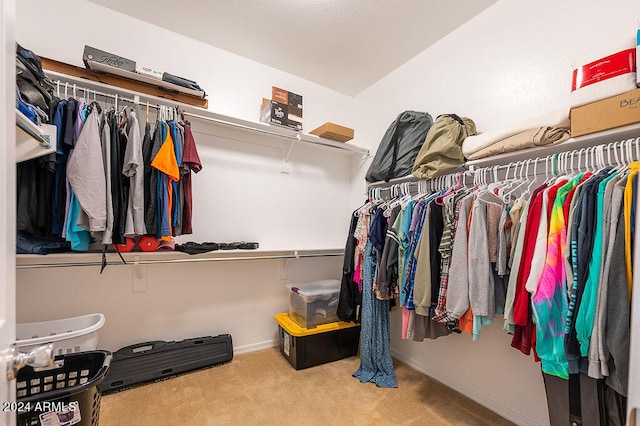 walk in closet featuring light colored carpet