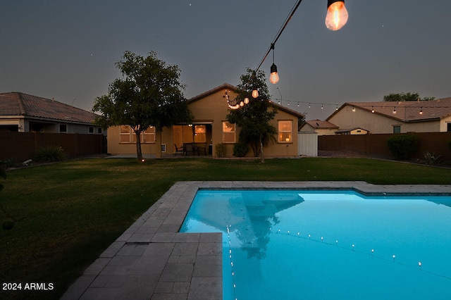 view of pool with a yard and a shed