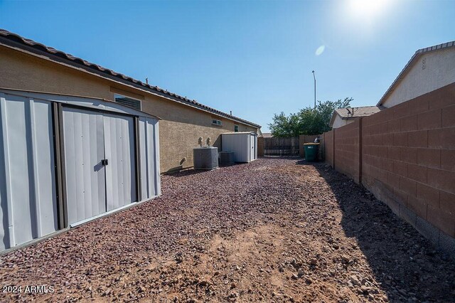 view of yard featuring central AC unit and a shed