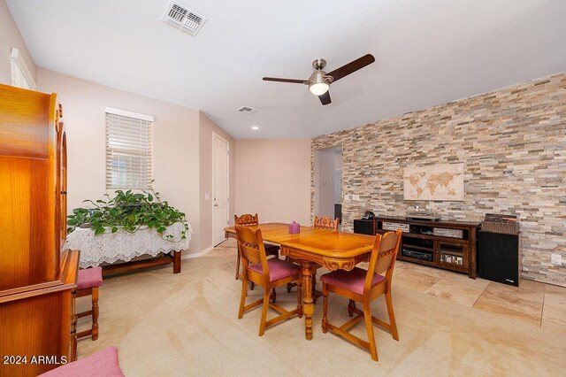 carpeted dining area with ceiling fan