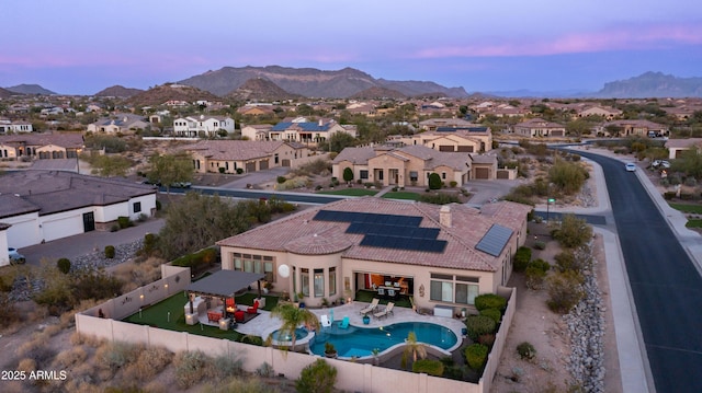 aerial view at dusk featuring a residential view and a mountain view