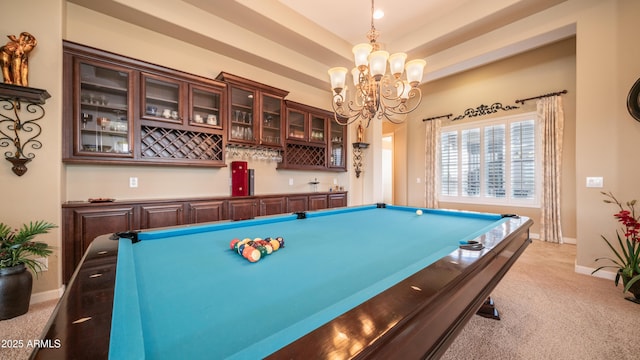 recreation room with a chandelier, light colored carpet, bar area, baseboards, and a tray ceiling