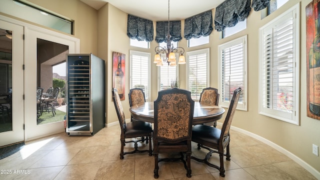 dining room featuring a chandelier, wine cooler, plenty of natural light, and baseboards