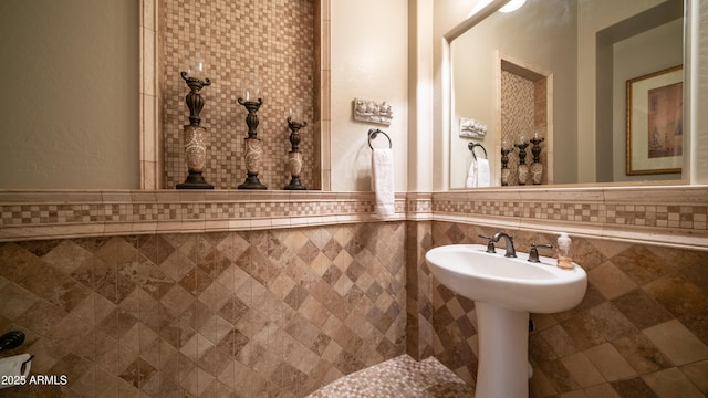 bathroom with wainscoting and tile walls