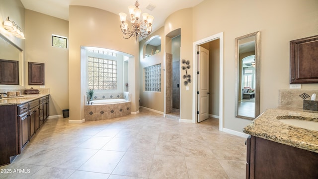 bathroom with a sink, a garden tub, a walk in shower, and two vanities