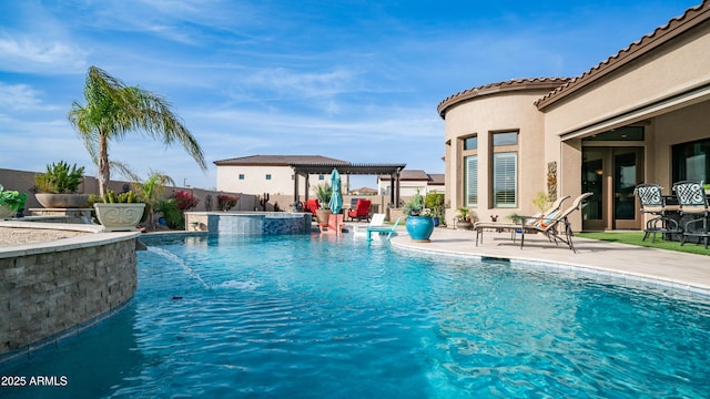 view of swimming pool with a pool with connected hot tub, fence, a pergola, and a patio