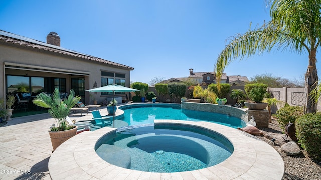 view of pool with a pool with connected hot tub, a fenced backyard, and a patio