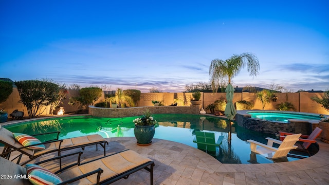 view of pool with a patio area, a fenced backyard, and a pool with connected hot tub