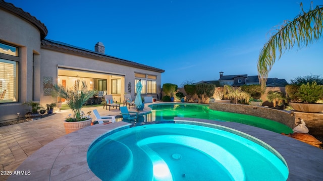 view of swimming pool with a pool with connected hot tub and a patio area