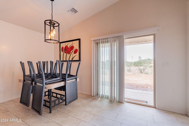 tiled dining area featuring an inviting chandelier and vaulted ceiling