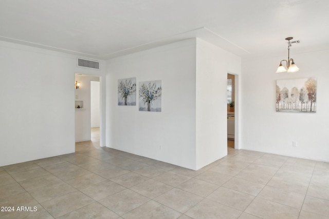 tiled empty room featuring an inviting chandelier