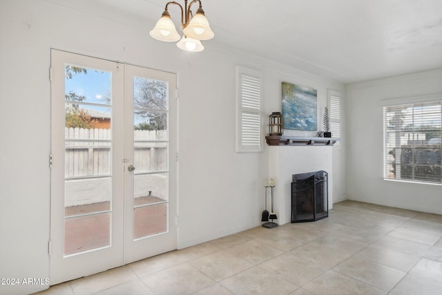 entryway with an inviting chandelier, light tile patterned floors, and french doors