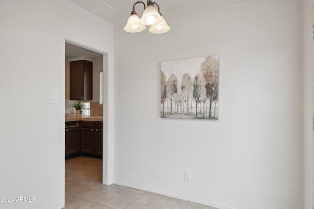 corridor with a notable chandelier and light tile patterned floors