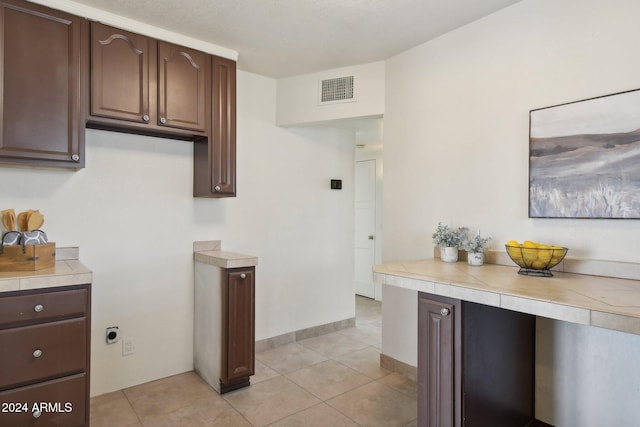 kitchen with light tile patterned flooring and dark brown cabinetry