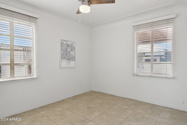 empty room with ceiling fan and light tile patterned flooring