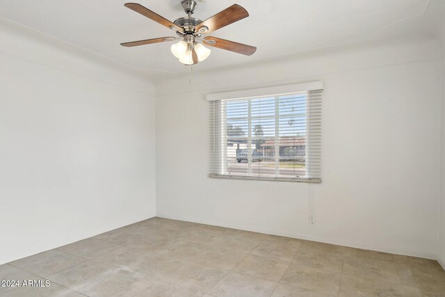 tiled spare room with ceiling fan