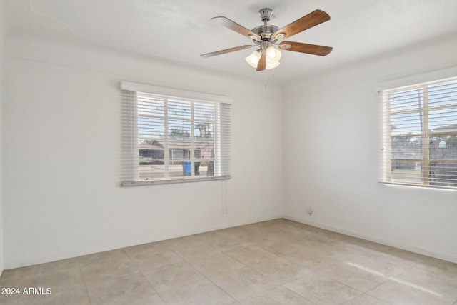 tiled spare room with ceiling fan and a healthy amount of sunlight