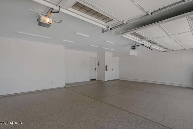 garage featuring a garage door opener and baseboards