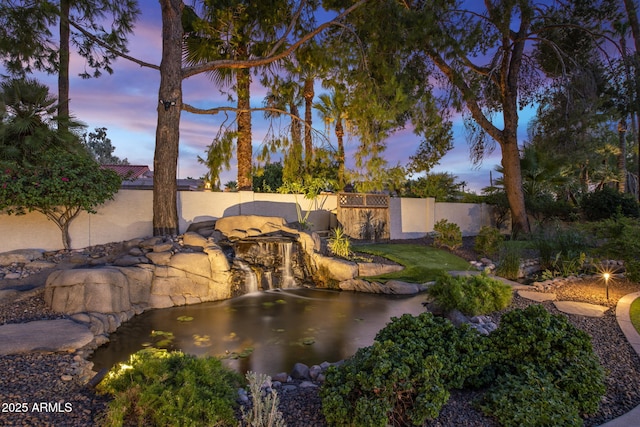 view of pool with fence and a garden pond