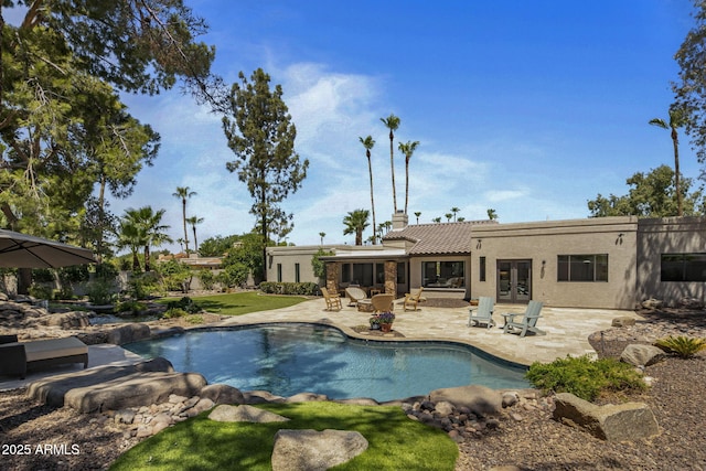 outdoor pool featuring french doors and a patio