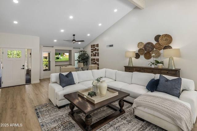 living room featuring high vaulted ceiling, recessed lighting, visible vents, light wood-style floors, and beamed ceiling