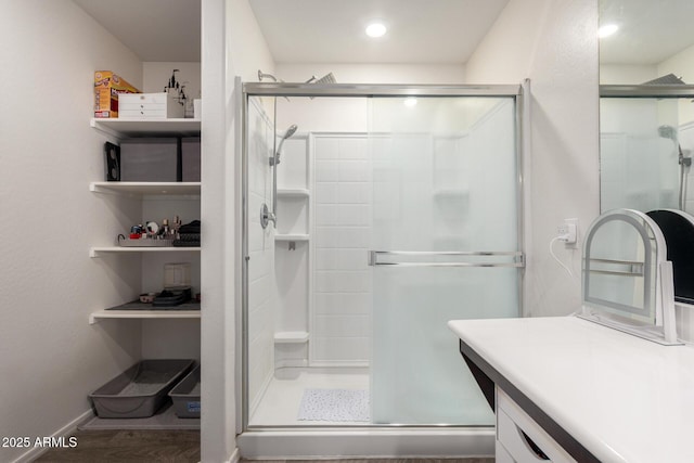 bathroom featuring hardwood / wood-style floors, an enclosed shower, and vanity