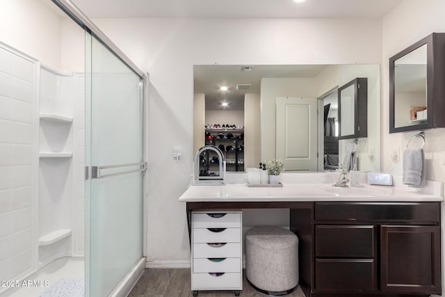 bathroom featuring an enclosed shower and vanity