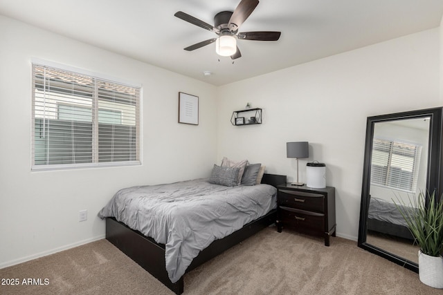 bedroom with ceiling fan, light colored carpet, and multiple windows