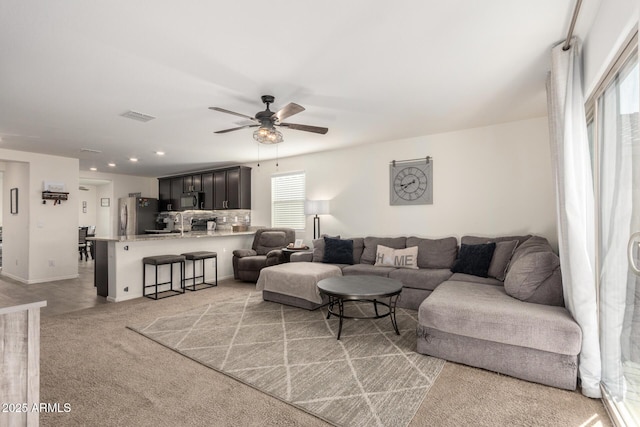 living room with ceiling fan and light colored carpet