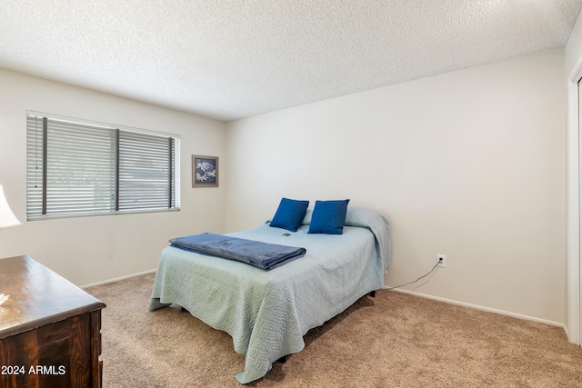 carpeted bedroom featuring a textured ceiling