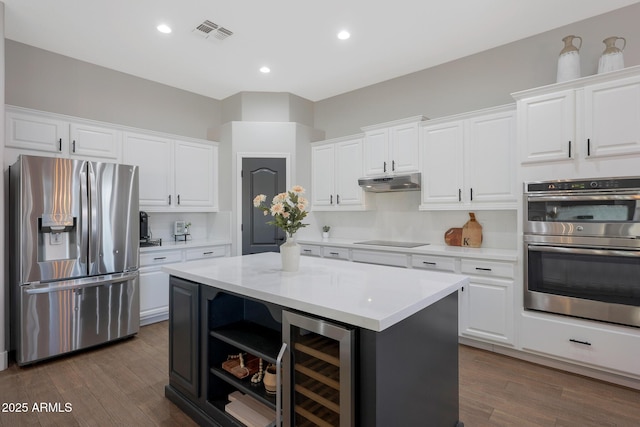 25454 N 73rd Ave, Peoria, AZ 85383 - kitchen featuring wine cooler, a kitchen island, under cabinet range hood, stainless steel appliances, and visible vents