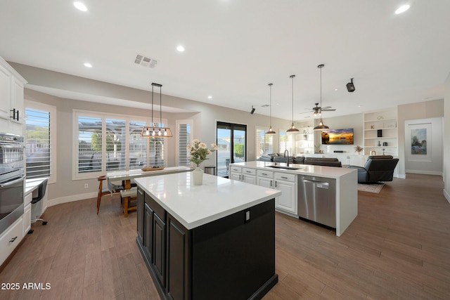 25454 N 73rd Ave, Peoria, AZ 85383 - kitchen with visible vents, wood finished floors, stainless steel appliances, a center island with sink, and a sink