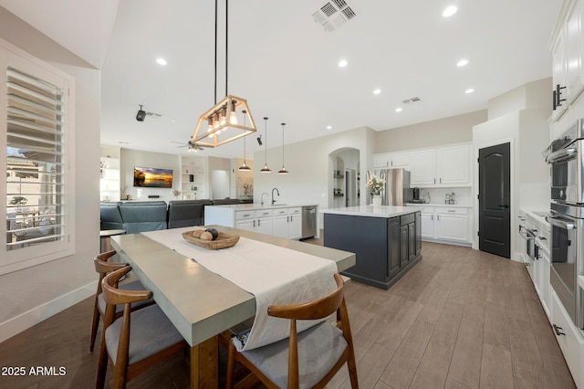 25454 N 73rd Ave, Peoria, AZ 85383 - dining space with light wood-style flooring, visible vents, arched walkways, ceiling fan, and recessed lighting