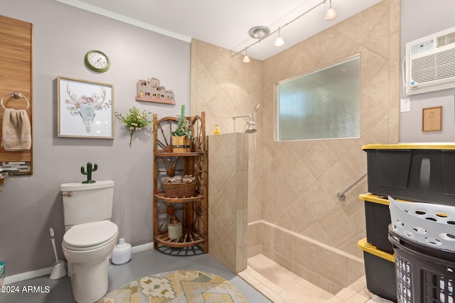 bathroom with an AC wall unit, track lighting, and toilet