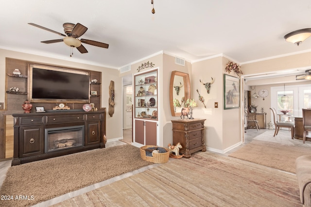 living room with ornamental molding and ceiling fan