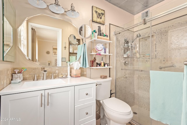 bathroom featuring tile walls, tasteful backsplash, a shower with shower door, toilet, and vanity