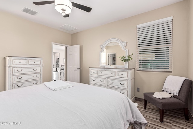 bedroom with wood finished floors, visible vents, and ceiling fan