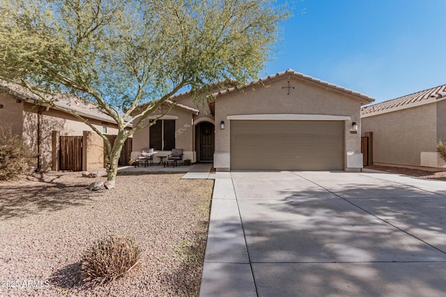 view of front of home featuring stucco siding, a garage, driveway, and a tiled roof