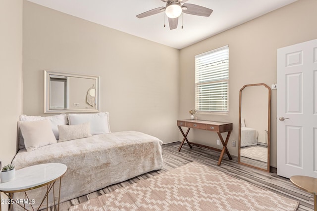 bedroom featuring ceiling fan, baseboards, and light wood-style floors