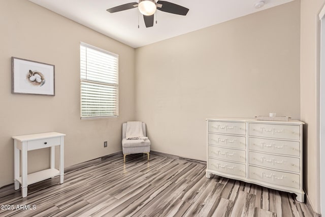 sitting room with ceiling fan and wood finished floors