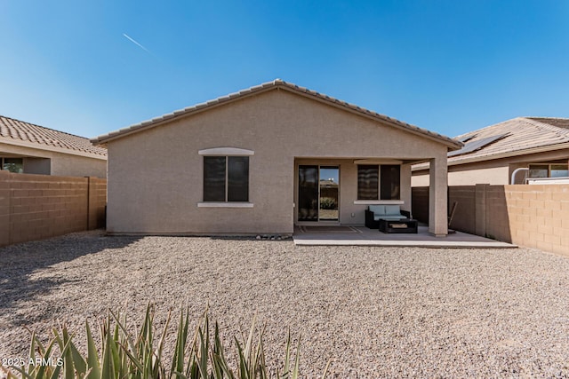 rear view of house with a patio, a fenced backyard, and stucco siding