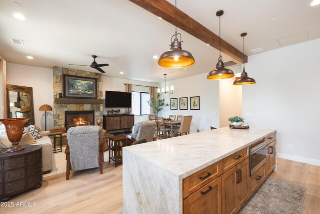 2582 S Cottonrose Ln, Flagstaff, AZ 86001 - kitchen with ceiling fan, light wood-style floors, stainless steel microwave, pendant lighting, and open floor plan