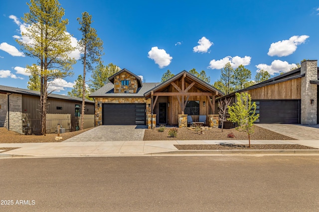2582 S Cottonrose Ln, Flagstaff, AZ 86001 - view of front of property featuring decorative driveway, a garage, stone siding, and roof with shingles