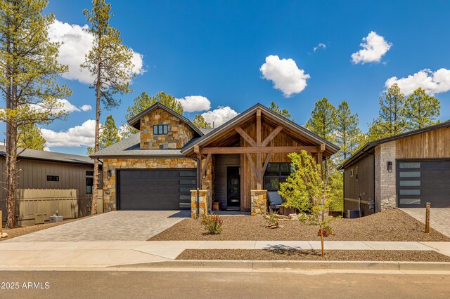 2582 S Cottonrose Ln, Flagstaff, AZ 86001 - view of front of house with stone siding, decorative driveway, and a garage