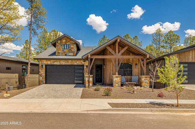 2582 S Cottonrose Ln, Flagstaff, AZ 86001 - view of front of house featuring stone siding, decorative driveway, a garage, roof with shingles, and a porch