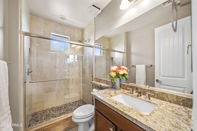 bathroom featuring toilet, walk in shower, and vanity