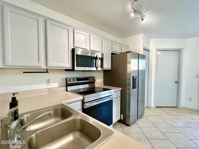 7801 N 44th Dr Unit 1180, Glendale, AZ 85301 - kitchen featuring appliances with stainless steel finishes, light tile patterned floors, light countertops, white cabinetry, and track lighting