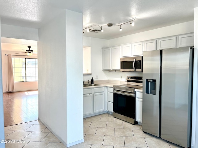 7801 N 44th Dr Unit 1180, Glendale, AZ 85301 - kitchen with stainless steel appliances, ceiling fan, light tile patterned floors, a textured ceiling, and white cabinetry
